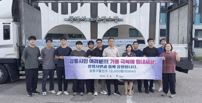8일 오전 광명시 노온정수장 앞에서 직원들이 강릉으로 배송할 병입 수돗물 '구름산수'를 배경으로 기념사진을 촬영하고 있다.