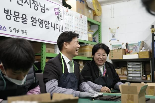 조용익 부천시장이 ㈜애플하우스 김경숙 대표, 발달 장애인 직원들과 함께 커피박 재활용 제품 제작을 함께하고 있다.